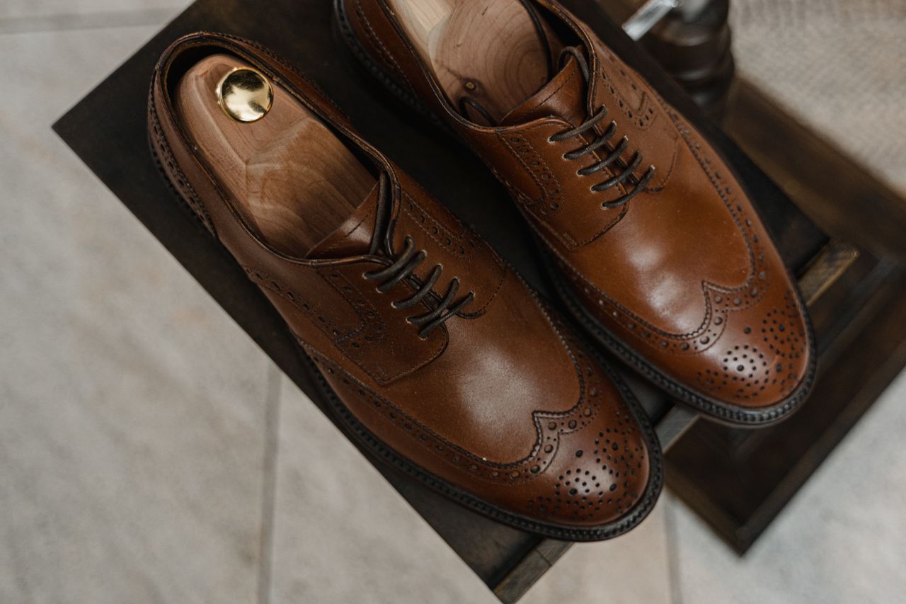 journey Close-up of luxurious brown leather Oxford shoes with perforated design.